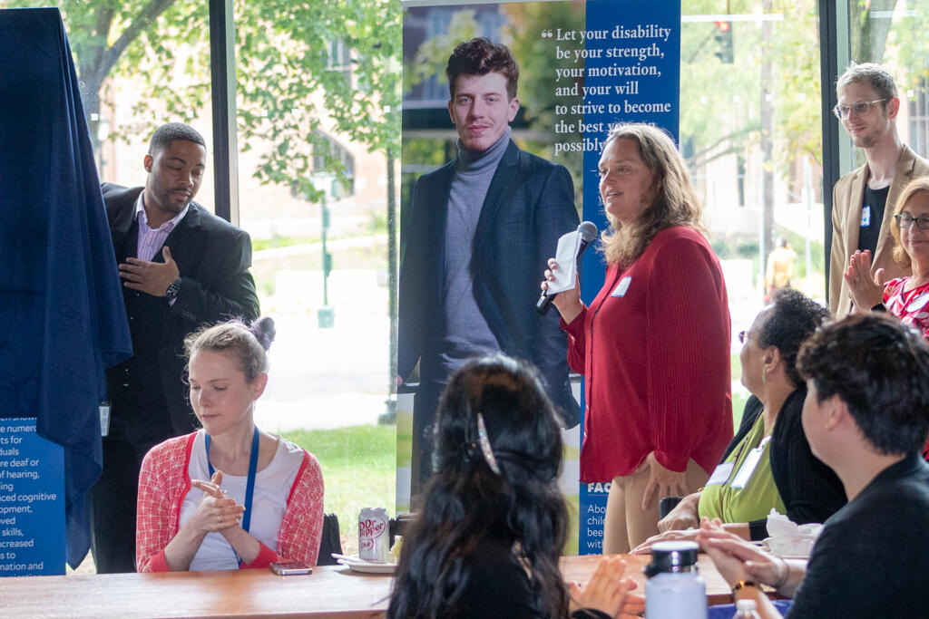  Former DAY co-chair Amy Holt presenting the banner featuring DAY Steering Committee member Nicholas Simons.